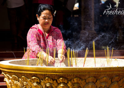 Gläubige spendet Räucherstäbchen für die Erfüllung ihrer Wünsche.