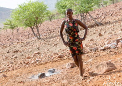 Junge Himba Frau, die gerade Schulferien hat und die Familie besucht